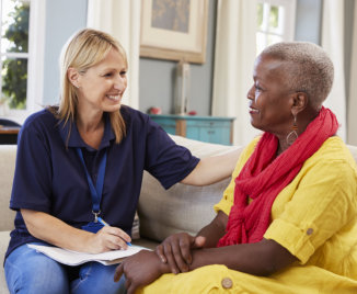 a female caregiver with an elderly woman talking