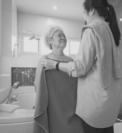 a female caregiver helping an elderly woman